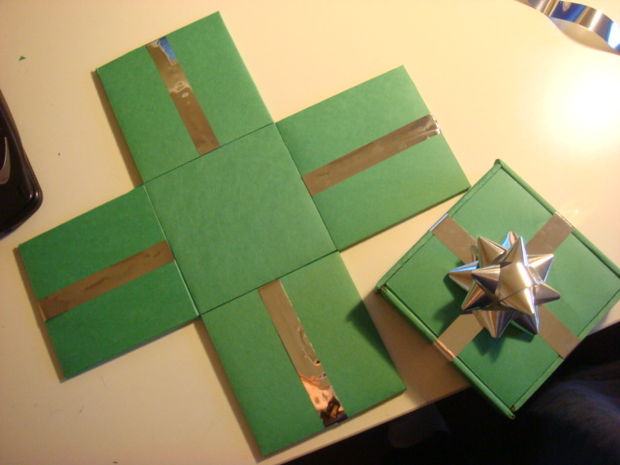 Gift box decorated with silver ribbon cross design