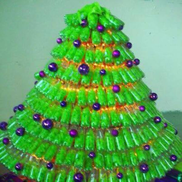 Christmas tree with green plastic bottles with shiny purple balls