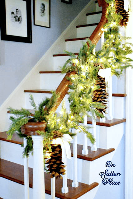 Beautiful Light Garland Decoration On Stairs With Pinecones