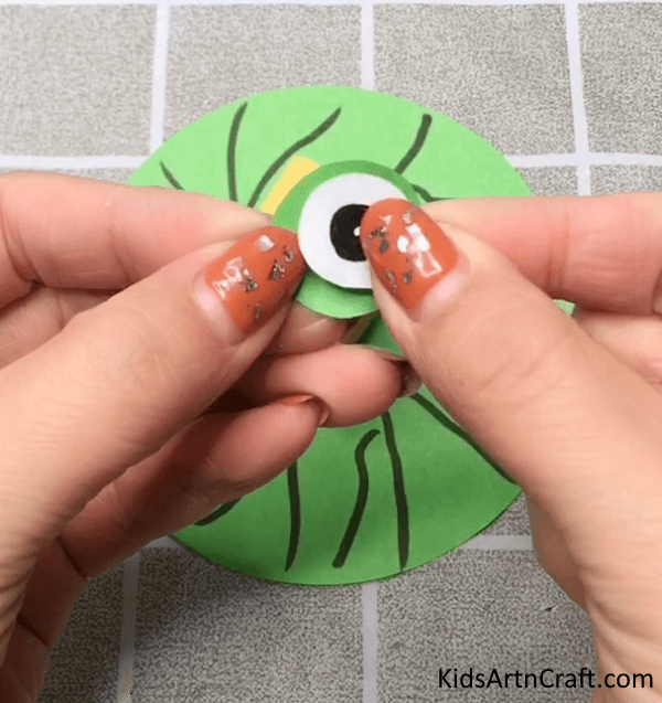 Pasting Eyes On Slinky Frog Craft Made Of Paper