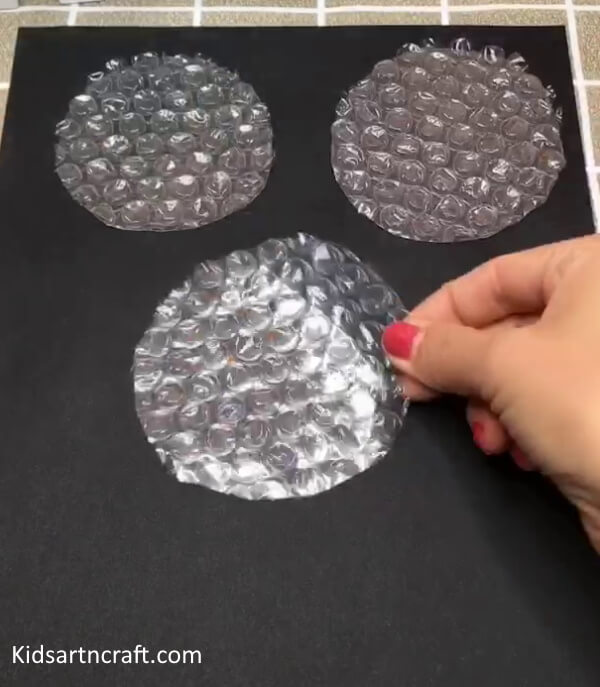 Cutting The Bubble Wrap In Circles To Make Flower Craft For Kids