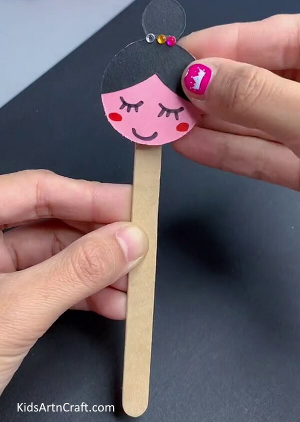 Pasting The Face Over A Popsicle Stick-Paper Ballerina Craft Tutorial For Kids