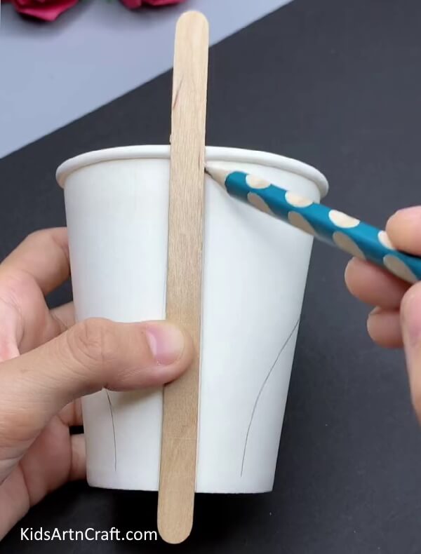 Tracing Popsicle Stick With Pencil - How to Create a Recycled Paper Cup Swan With Your Little Ones