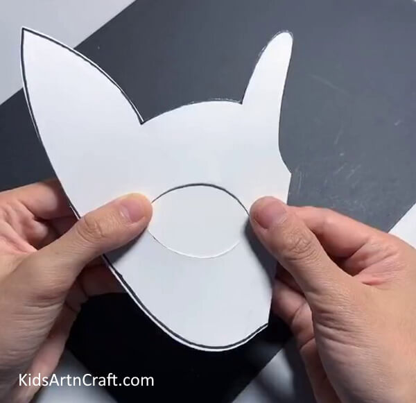 Cutting Out The Eyes- Make a paper mask for kids with this step-by-step guide. 