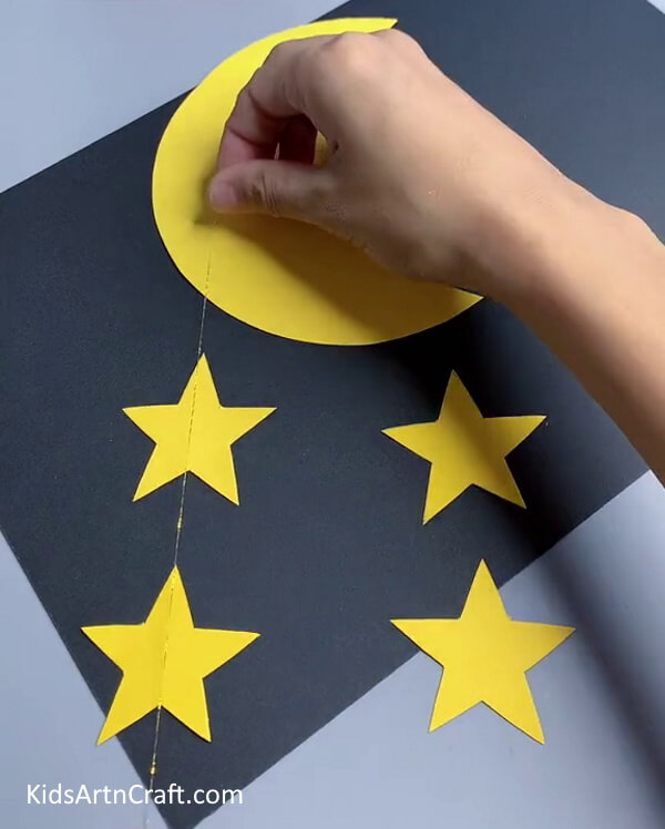 Sticking The Thread On The Shapes- Assembling a Wall Accent with Paper Moons and Stars for Kids