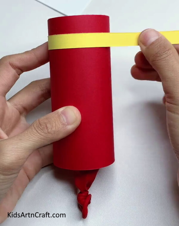  Wrapping A Yellow Paper Strip - Put Together a Cheerful Party Popper with Your Kids