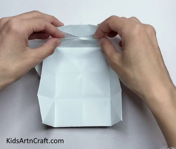 Folding Sides Of The Paper To The Middle Crease - An innovative paper box craft for the young ones.