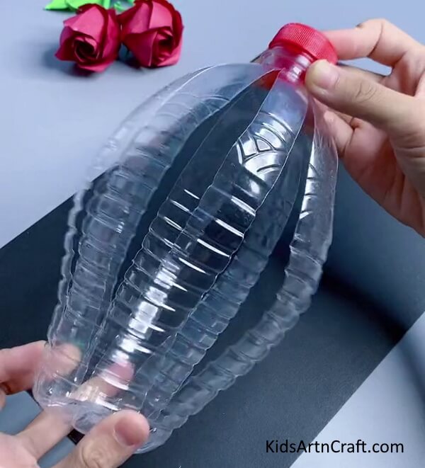 Pressing the bottle from both side. Tutorial for Easy Bunny Craft Using Recycled Plastic Bottles for beginners
