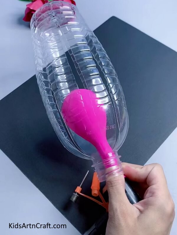 Inserting balloon into bottle. Step-by-step guide of making a Easy Bunny Craft Using Recycled Plastic Bottles for kids