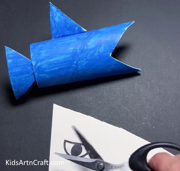 Cutting the Eye Out of The Paper - Reusing cardboard tubing to craft a shark-related project for kids.