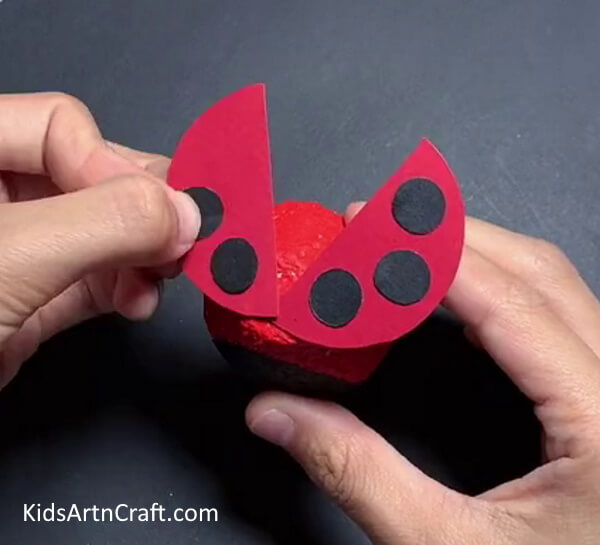 Pasting Black Circles- Creating a Ladybug Item from a Recycled Egg Tray 