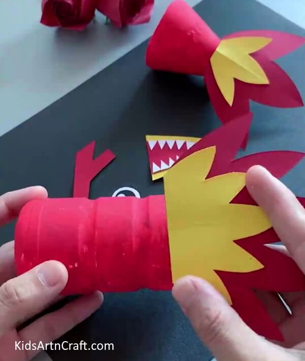 Pasting Crown Shape On Bottle - A fun and easy activity for small ones to make a dragon out of paper and plastic bottles. 