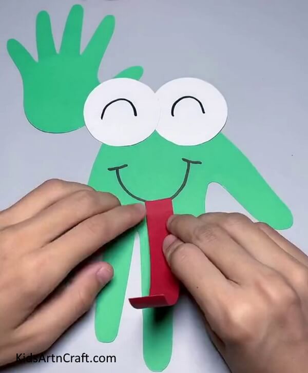 Paste The Red Paper Cutout On The Mouth Of The Frog-Creating a Frog with Handprints and Paper - Fun Kids Craft 