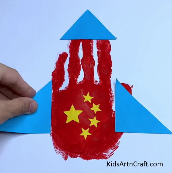 Placing Blue Triangle On the Left - How to Create a Handprint Paper Rocket - A Guide for Kids.
