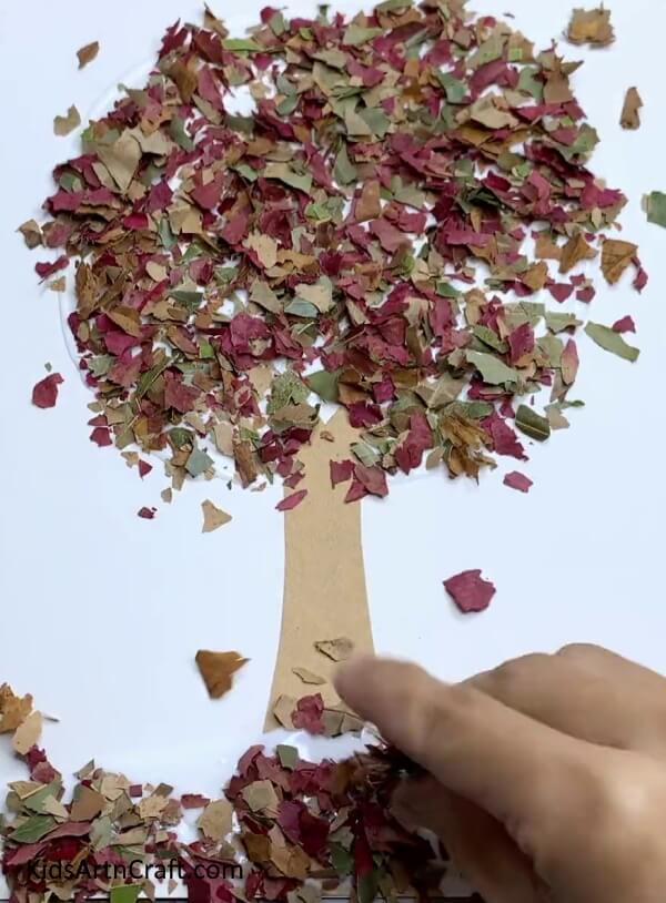 Pasting Leaves On Ground - An effortless, leaf-based tree craft for the autumnal season.