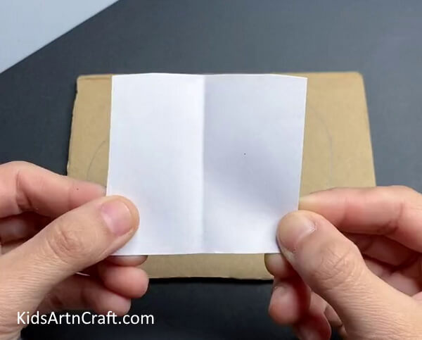 Folding A Square of White Paper In Half - A Simple Tutorial For A Wall-Hanging Animal Craft For Kids