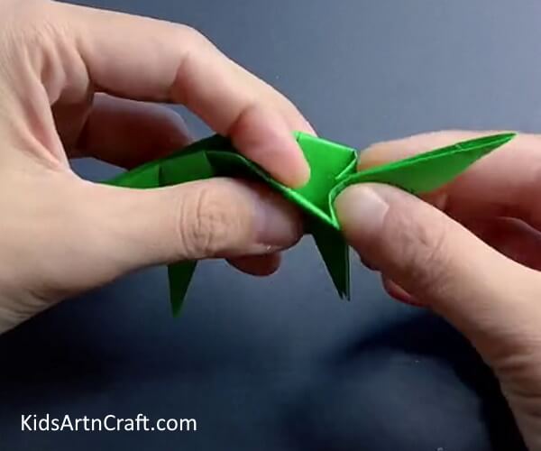 Pushing In The Triangle - Find out how to make a paper dinosaur using origami.