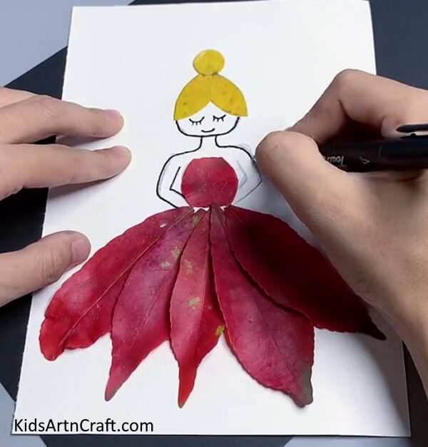 Making the outline and adding special facial features. To Make fall leaf artwork for beginners