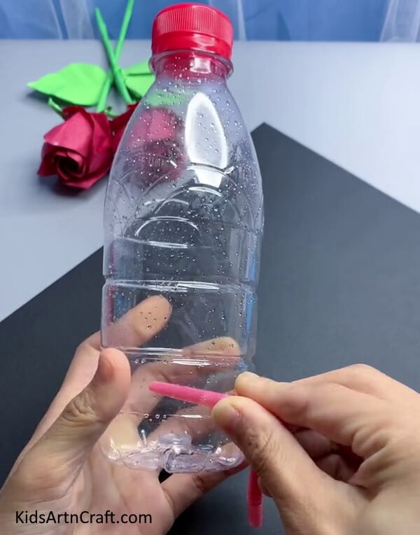 Inserting Straw In Bottle - Crafting a Recyclable Water Dispenser Using Plastic Jugs and Straws