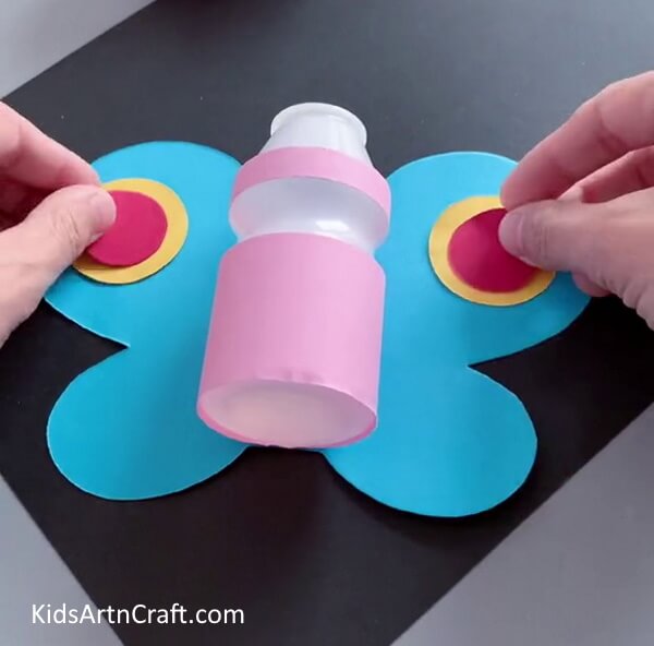 Pasting Circles On Wings - Making a Butterfly Craft Out of a Reused Bottle