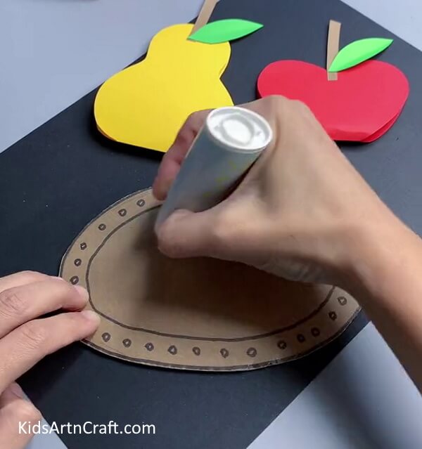 Spreading Glue - Show your kids how to assemble 3D paper fruit art. 