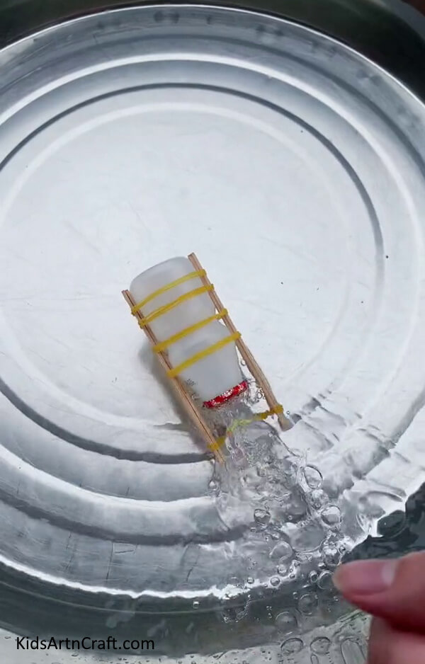 Placing Boat In Water - Forming a Boat From a Bottle, Rubber Band, and Popsicle Sticks