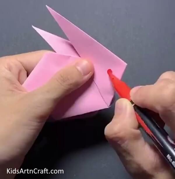 Adding Details With Red Marker Crafting an Origami Bunny from Yellow Paper Sun