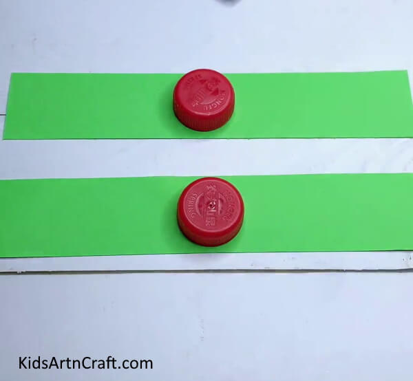 Placing Bottle Caps On Strips - Self-Made Frog Craft Utilizing Paper Ribbons