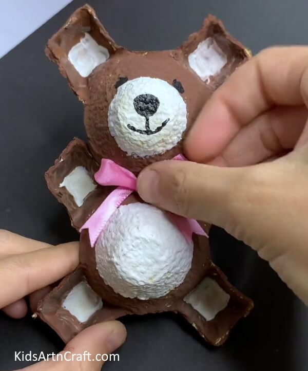 Adding A Cute Bow - Kids' Guide to Crafting a Bunny Out of a Pre-Owned Egg Carton 
