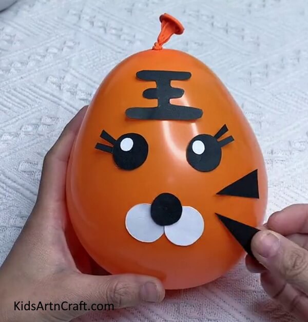 Make Face Stripes With Black Craft Paper-Detailed Guide to Crafting a Tiger Balloon for Kids 