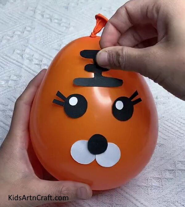 Make Forehead Stripes With Black Craft Paper-Step-by-step guide to making a Tiger Balloon for Children