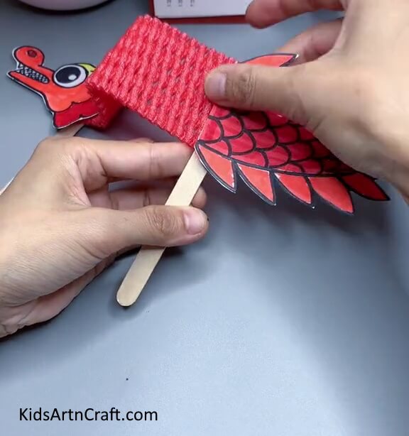 Pasting Dragon's Tail On Popsicle Stick - Arranging a Foam Net Dragon – An Uncomplicated Craft for First-timers