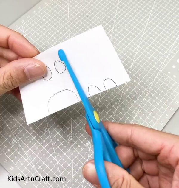 Cutting The Patterns On The White Paper - Alluring Tiger Paper Cup Art Project For Kids 