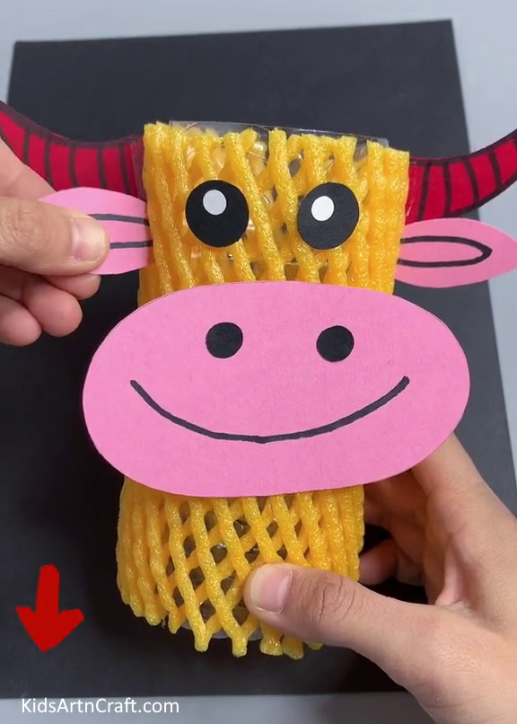 Pasting Ears And Horns - A cow-shaped item handcrafted from fruit foam, a net, and a plastic bottle.