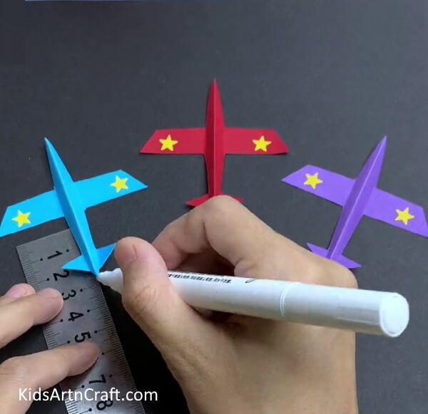Drawing White Line For The Blue Airplane - A straightforward guide on how to make a paper airplane, designed especially for kids. 