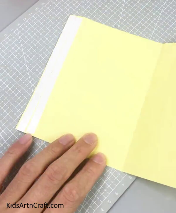 Folding Yellow Paper In Half - Construct an Engaging Paper Sweet Craft For Kids