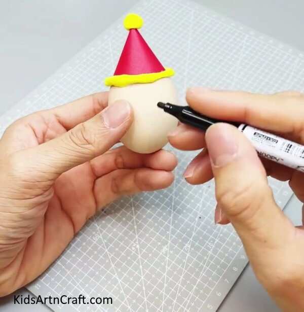 Making Face Of Shell Using Markers - Get the Kids Involved and Build an Eggshell Elf for Christmas.