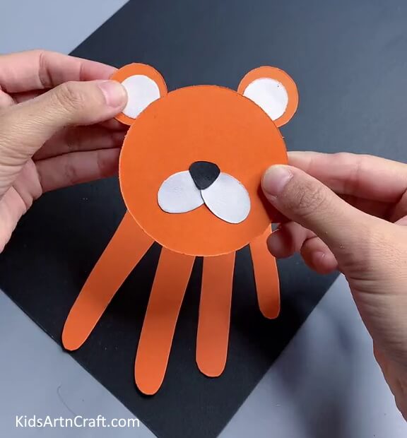 Pasting The Ears-A fun Handprint Tiger craft for kids.