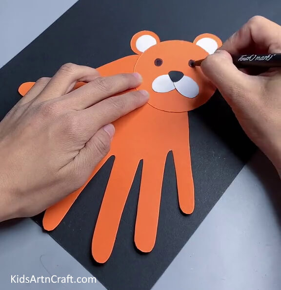 Drawing Eyes On The Tiger- Crafting a Handprint Tiger is a great idea for kids.