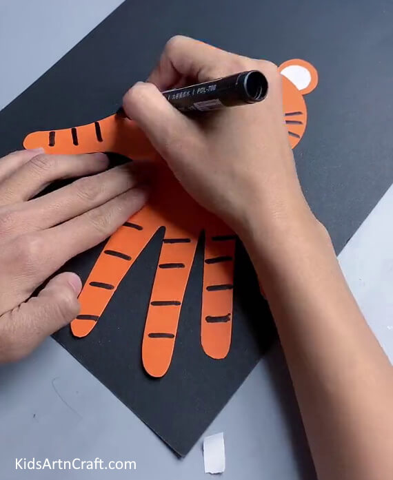 Drawing Stripes On The Body- A Handprint Tiger craft that kids can make.