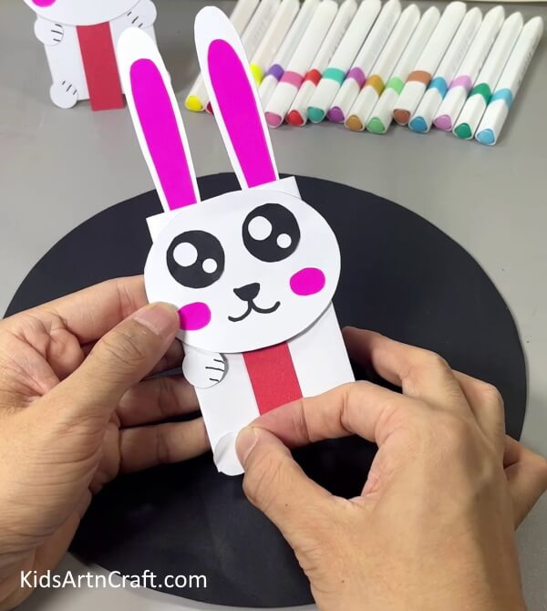 Pasting Legs Of Bunny - A Bunny craft made from handmade paper is a great activity for kids.