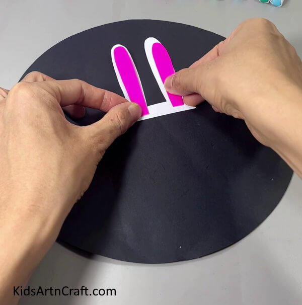 Pasting Pink Paper On Ears - Making a Bunny craft using handmade paper is something that kids can do. 