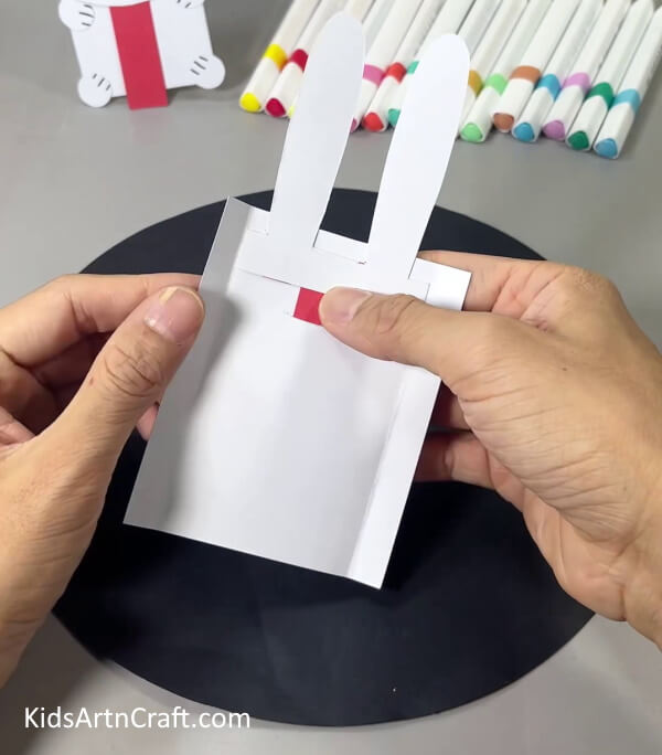 Attaching Paper Ears On White Paper - A handmade paper Bunny craft is a great project for children to make. 