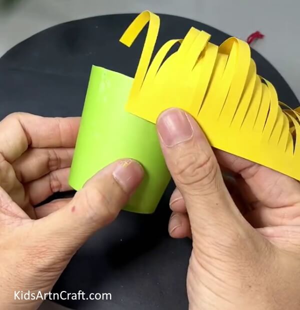 Pasting Yellow Paper Strand Around Paper Cup - Tutorial for a Do-It-Yourself Paper Flower Hanging