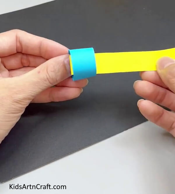 Inserting Yellow Paper Strip In Blue Ring - A straightforward paper worm craft for pre-schoolers.