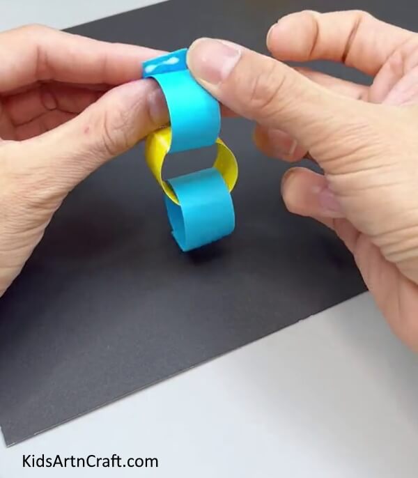 Making Blue Ring Attached To Yellow Ring - An effortless paper worm craft for kindergartners.