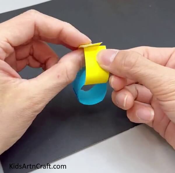 Folding Yellow Paper To Form A Ring - A simple paper worm craft for kindergartners.