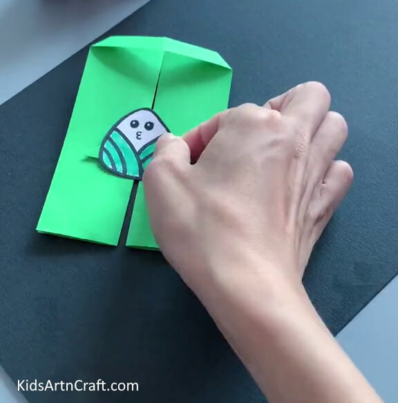 Pasting the Cute Cartoon on the Small Triangle - An engaging activity for children to make a paper toy craft.