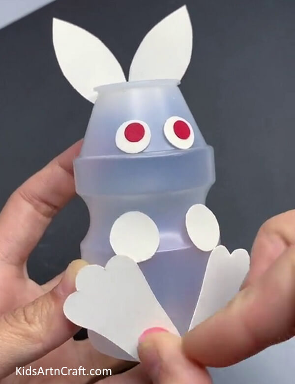 Pasting Pink Circles - Repurposing plastic bottles into a bunny: A fun craft for kids.