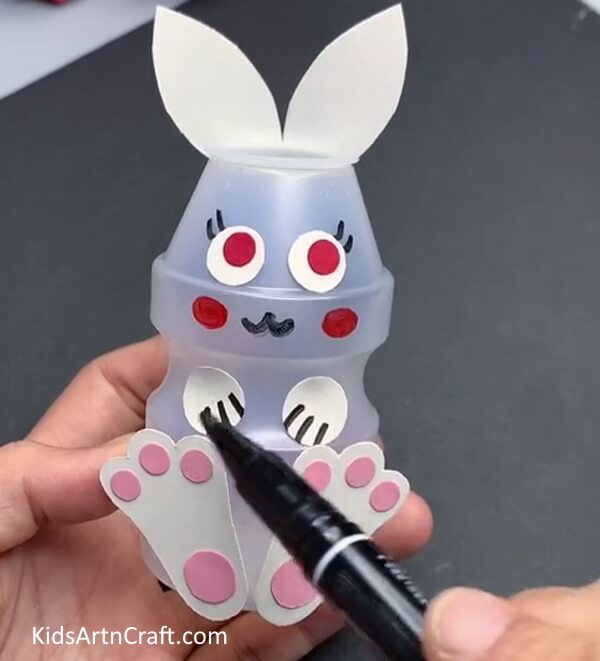 Drawing Details Using Black Marker - Crafting with children: Using recycled plastic bottles to create a bunny.